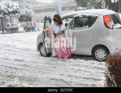 Tokorozawa, au Japon. 14 janvier 2013. Habillée d'une robe à manches longues de cérémonie, une femme japonaise se sortir d'une voiture sur son chemin d'assister à un passage à l'âge d'une cérémonie à Tokorozawa, banlieue ouest de Tokyo, dans la neige qui tombe le lundi, Janvier 14, 2013. Sur 1 220 000 personnes en 20 ans ont célébré leur passage à l'âge dans tout le Japon. Une tempête d'hiver freak pouces de neige, couvrant la zone métropolitaine de Tokyo et ses environs avec des couvertures de première neige de la saison. (Photo de Natsuki Sakai/AFLO) AYF -mis- Banque D'Images