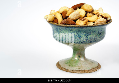 Noix mélangées dans un bol brun avec un fond blanc Banque D'Images