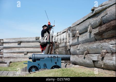 Fort Stanwix reenactors : Continental américain soldat d'artillerie prépare à fire musket derrière les murs du fort. Banque D'Images