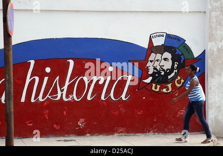 Un piéton passe devant un mur avec un graffiti sur elle qui décrit entre autres les chefs de Fidel Castro (C) et Ernesto Che Guevara (R) et l'écriture "Historia" (lit. histoire) à La Havane, Cuba, 21 janvier 2012. Photo : Friso Gentsch Banque D'Images