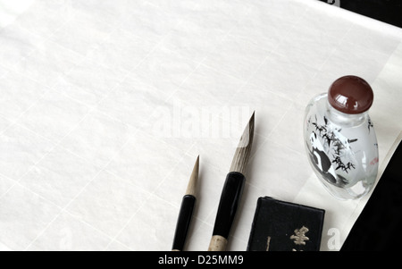 Chinois de calligraphie sur table avec pinceau, l'encre et du papier. Banque D'Images