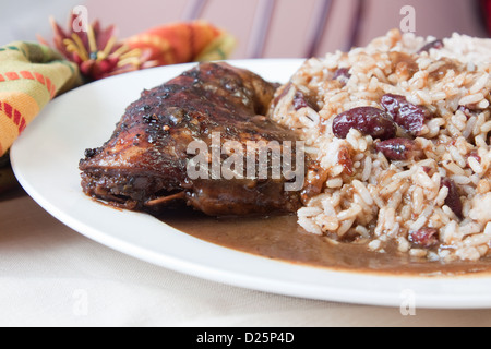 Style des Caraïbes poulet servi avec du riz mélangé avec des haricots rouges. L'accent sur le poulet peu profondes. Banque D'Images