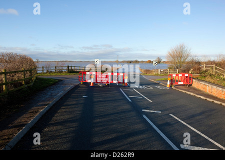 Un petit chemin rural submergé par les eaux de crue avec route fermée signes et les barrières dans un paysage d'hiver Banque D'Images