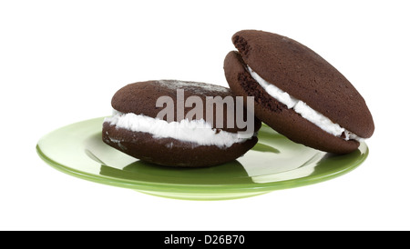 Deux whoopie pies sur une plaque verte sur un fond blanc. Banque D'Images