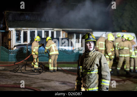 Les pompiers s'attaque à un brasier dans un bungalow qui a pris feu après que la chaudière a explosé dans la cuisine. Banque D'Images