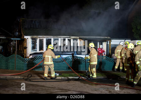 Les pompiers s'attaque à un brasier dans un bungalow qui a pris feu après que la chaudière a explosé dans la cuisine. Banque D'Images