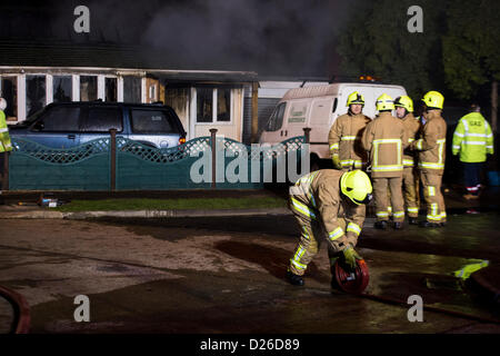 Les pompiers s'attaque à un brasier dans un bungalow qui a pris feu après que la chaudière a explosé dans la cuisine. Banque D'Images