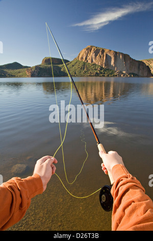 Mains d'un pêcheur de mouche à l'aide d'une mouche road à Canyon Lake en Arizona Banque D'Images