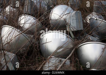 Lampes de rue sont abandonnés dans les mauvaises herbes dans une zone de la décharge municipale. Banque D'Images