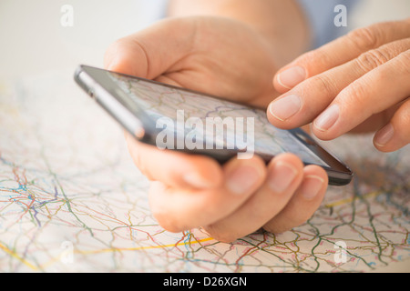 Close-up de la main à l'aide de blackberry sur la carte Banque D'Images