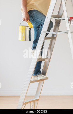 USA, New Jersey, Jersey City, Man holding paint peut et escalier de remonte Banque D'Images