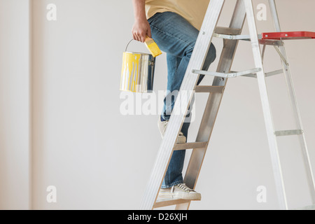 USA, New Jersey, Jersey City, Man holding paint peut et escalier de remonte Banque D'Images