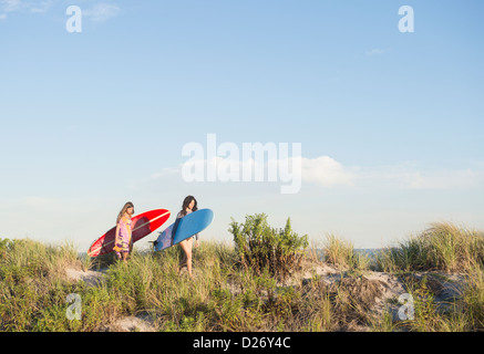 USA, New York State, Rockaway Beach, deux femmes surfers walking on beach Banque D'Images