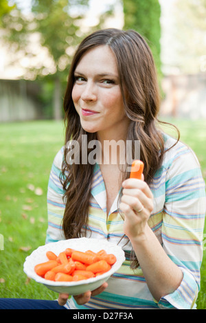 USA, Utah, Salt Lake City, portrait of mid adult woman eating carrots Banque D'Images
