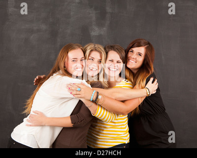 Portrait de quatre femmes embracing Banque D'Images