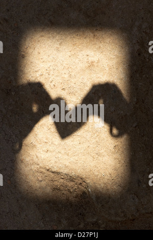 Ombre de filles indiennes hands holding heart shape sur sol texturé en Inde Banque D'Images