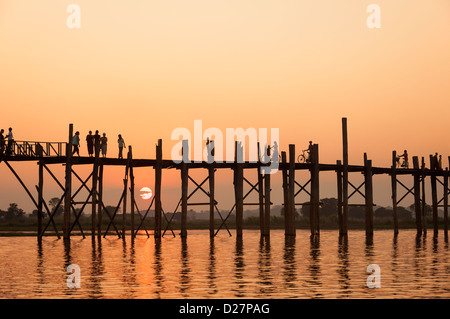 Les gens qui marchent sur le pont en teck le plus long du monde au coucher du soleil, la Birmanie Banque D'Images