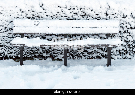 Banc de parc couvert de neige en hiver, Norfolk, Angleterre Banque D'Images