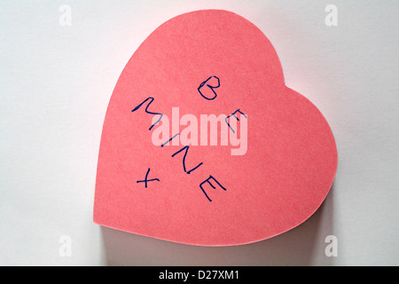 Être la mienne x message écrit sur en forme de coeur rose post-it-notes isolé sur fond blanc Banque D'Images