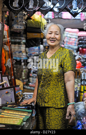 Hauts femme dans son magasin du marché, Hue, Vietnam Banque D'Images