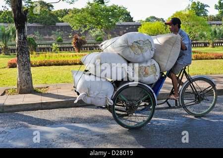 L'homme portent des sacs sur un tricycle à Hue, Vietnam Banque D'Images