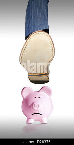 Homme Banker's foot stomping a piggy bank Banque D'Images