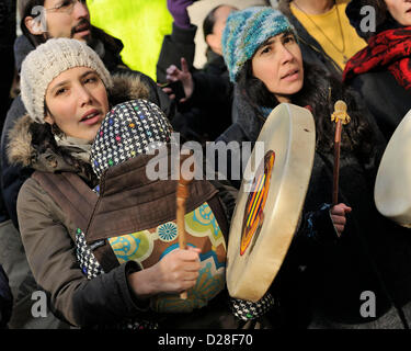 Toronto, Canada. 16 janvier 2013. Rallye d'Idle No More à l'extérieur du Consulat général britannique au centre-ville de Toronto dans le cadre de la journée d'action des Autochtones. Le mouvement Idle No More est un mouvement de protestation originaire chez les Premières Nations au Canada en réaction aux allégations de violations des droits de l'homme traité par le gouvernement Harper et prend un problème avec le projet de loi Le projet de loi C-45. En photo, une mère portant un enfant avec tambour à main. Crédit : n8n photo / Alamy Live News Banque D'Images