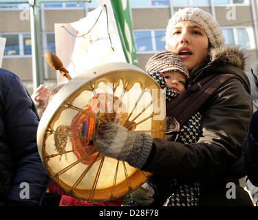 Toronto, Canada. 16 janvier 2013. Rallye d'Idle No More à l'extérieur du Consulat général britannique au centre-ville de Toronto dans le cadre de la journée d'action des Autochtones. Le mouvement Idle No More est un mouvement de protestation originaire chez les Premières Nations au Canada en réaction aux allégations de violations des droits de l'homme traité par le gouvernement Harper et prend un problème avec le projet de loi Le projet de loi C-45. En photo, une mère portant un enfant avec tambour à main. Crédit : n8n photo / Alamy Live News Banque D'Images