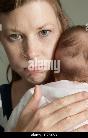 Angry mother holding baby Banque D'Images