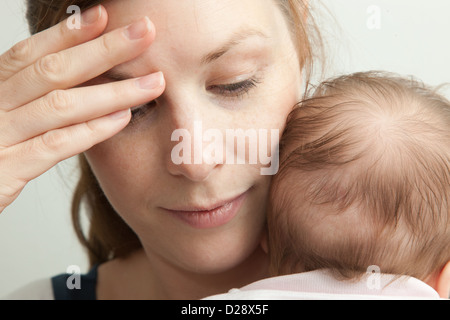 Fatigué mother holding jeune bébé Banque D'Images