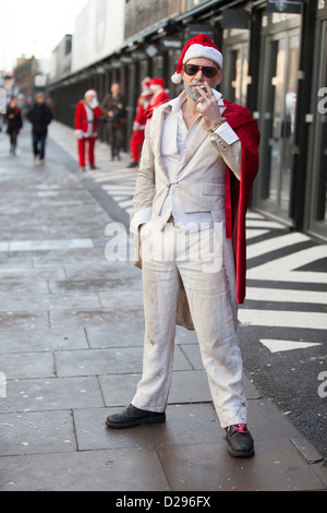 Un reveler à Santacon, Londres, décembre 2012, s'arrête pour une pause cigarette. Banque D'Images