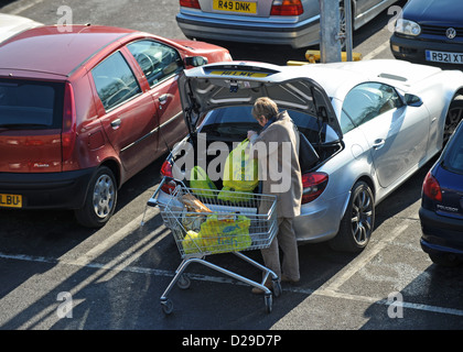 Femme sacs de chargement dans le coffre de sa voiture à l'extérieur de la ville d'un retail park Hollingbury Brighton UK Banque D'Images