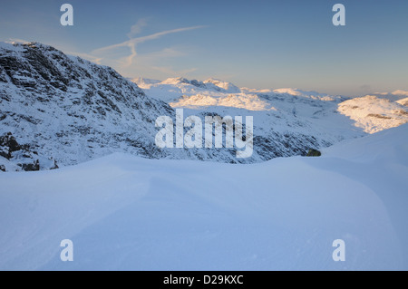 Les amoncellements de neige sur la bande de la prison sur la turbulence en hiver dans le Lake District, à l'égard Bowfell Banque D'Images