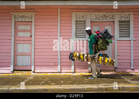Homme chaussures vente marche dernières petites maisons roses en Otra Banda, province de La Altagracia, République Dominicaine Banque D'Images
