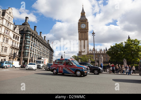 Un London cab avec un dessin du drapeau de l'Union entre la Place du Parlement avec les autres types de trafic avec Big Ben en arrière-plan. Banque D'Images