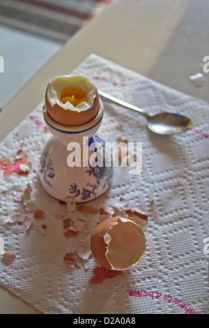 Un oeuf dur dans une tasse en partie de-décortiquées et prêt à être creusées dans et mangé Banque D'Images