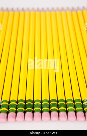 Une ligne de jaune, numéro 2 gommes crayon alignés sur un fond blanc. Banque D'Images