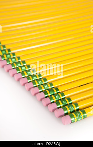Une ligne de jaune, numéro 2 gommes crayon alignés sur un fond blanc. Banque D'Images