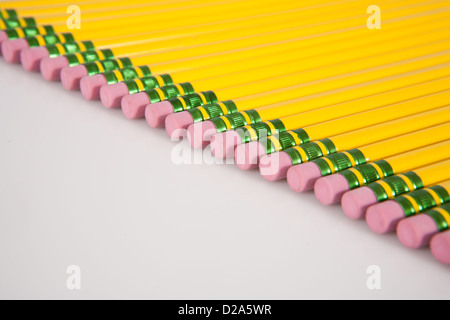 Une ligne de jaune, numéro 2 gommes crayon alignés sur un fond blanc. Banque D'Images