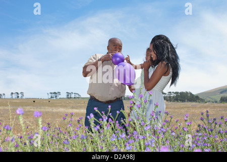 Family Playing with balloons in field Banque D'Images