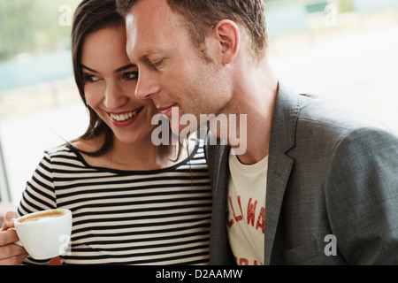 Smiling couple hugging in cafe Banque D'Images