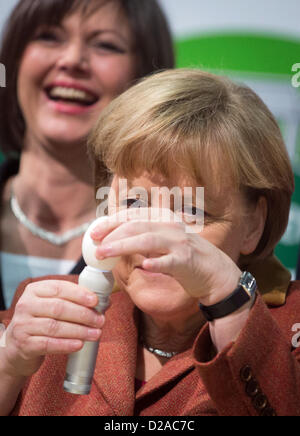 La chancelière allemande, Angela Merkel, un œuf tests en regard de l'Agriculture Ilse Aigner Ministre allemande pendant la visite de l'ouverture de la Semaine verte internationale de Berlin, Allemagne, 18 janvier 2013. Semaine verte internationale ouvre au public du 18 au 27 janvier 2013. Photo : MICHAEL KAPPELER Banque D'Images