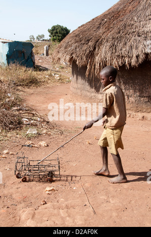 L'Ouganda. Cri - Garçon jouant avec chariot fabriqué à partir de fil Banque D'Images