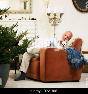 Plus man sleeping by Christmas Tree Banque D'Images