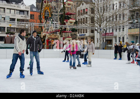 Allemagne, Cologne. Marché de Noël, les enfants et adolescents de patiner sur une patinoire. Banque D'Images