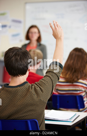 Student raising hand in classroom Banque D'Images