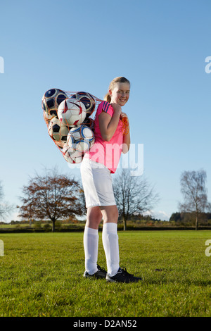 Joueur de football de transporter des ballons dans la zone