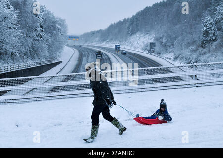 Autoroute M4. Cardiff, Royaume-Uni. Vendredi 18 janvier 2013. Un homme tire son enfant sur une luge sur un pont au-dessus de l'autoroute M4 près de Cardiff, Royaume-Uni. Le trafic est à peu de temps après l'avertissement de Nouvelle-Galles du Sud qui doivent se poursuivre sur la fin de semaine. Banque D'Images