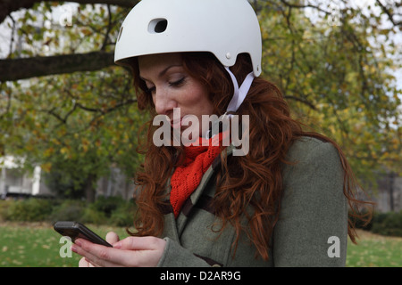 Woman using cell phone in park Banque D'Images