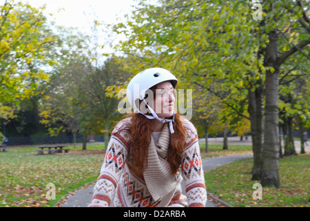 Woman riding bicycle in park Banque D'Images